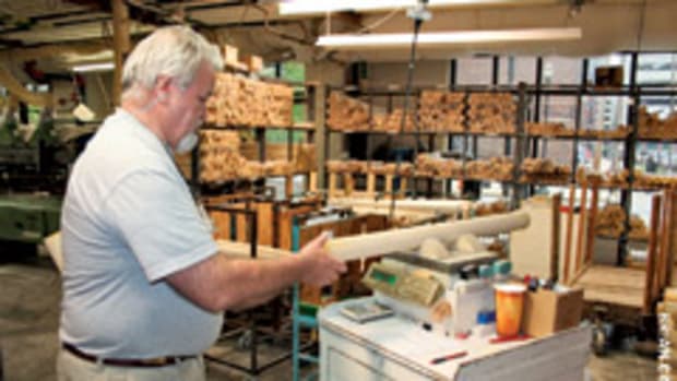 Danny Luckett, CNC operator for the pro bat department at Hillerich & Bradsby Co., weighs a 3" x 37" ash billet to ensure it meets quality standards.