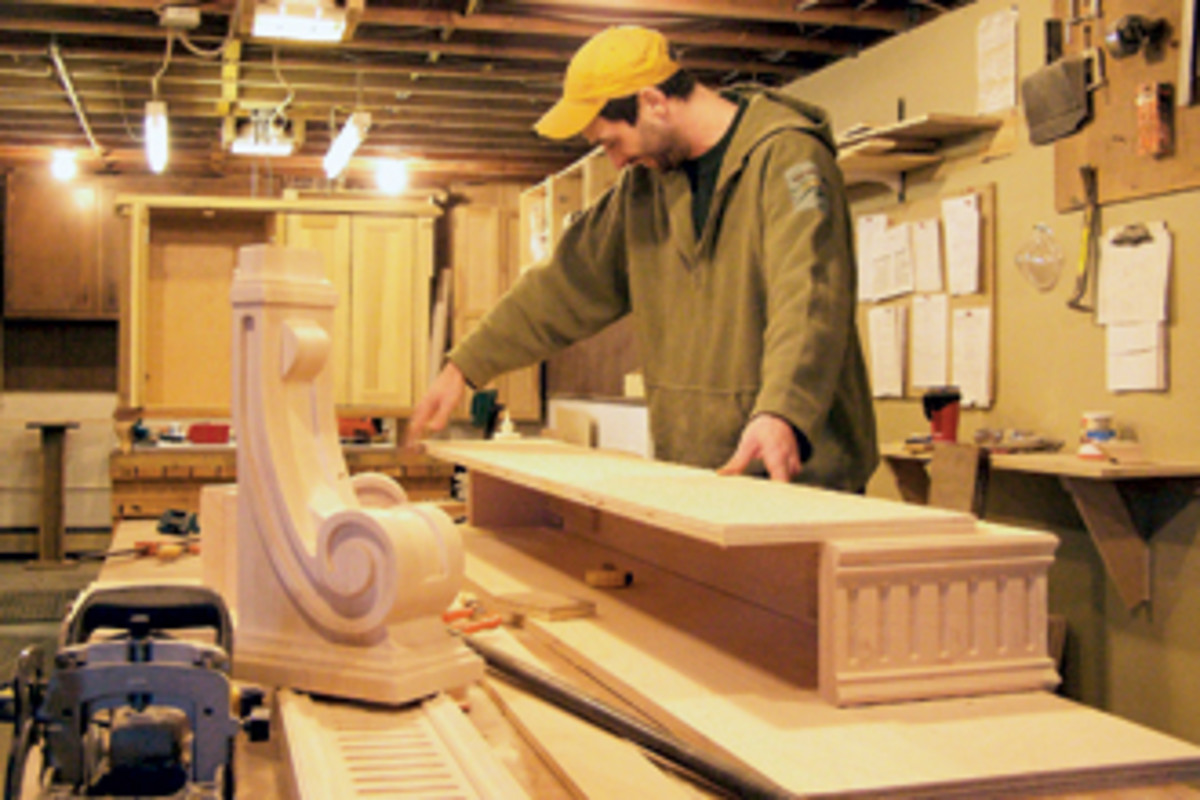 Russell Hudson Jr. assembles pieces for a fireplace mantle at his father's shop.