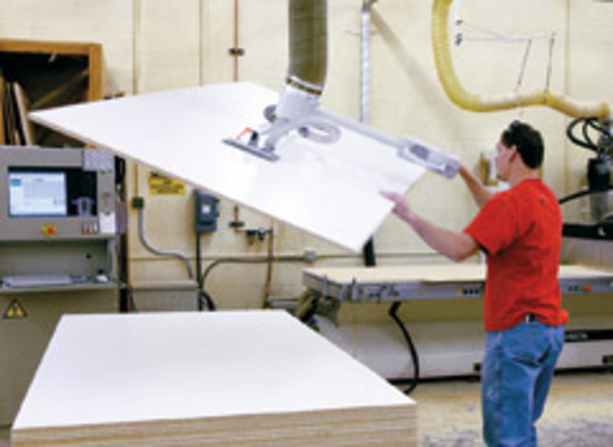 Brad Nicbaur takes a panel to the shop's Routech CNC machining center.