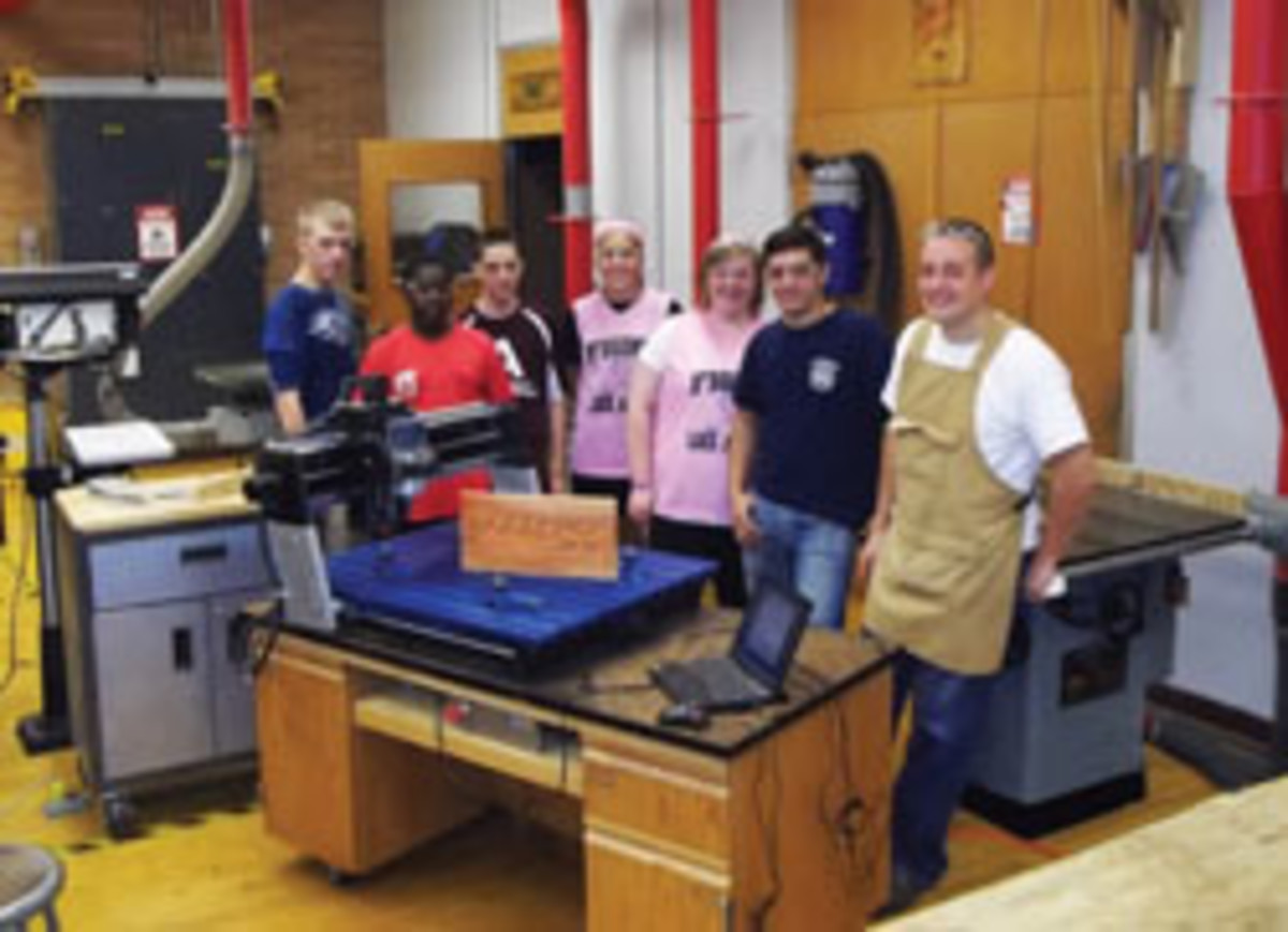 Justin Herrling shows his students how to work with the Rockler CNC machine he paid for with a local grant.
