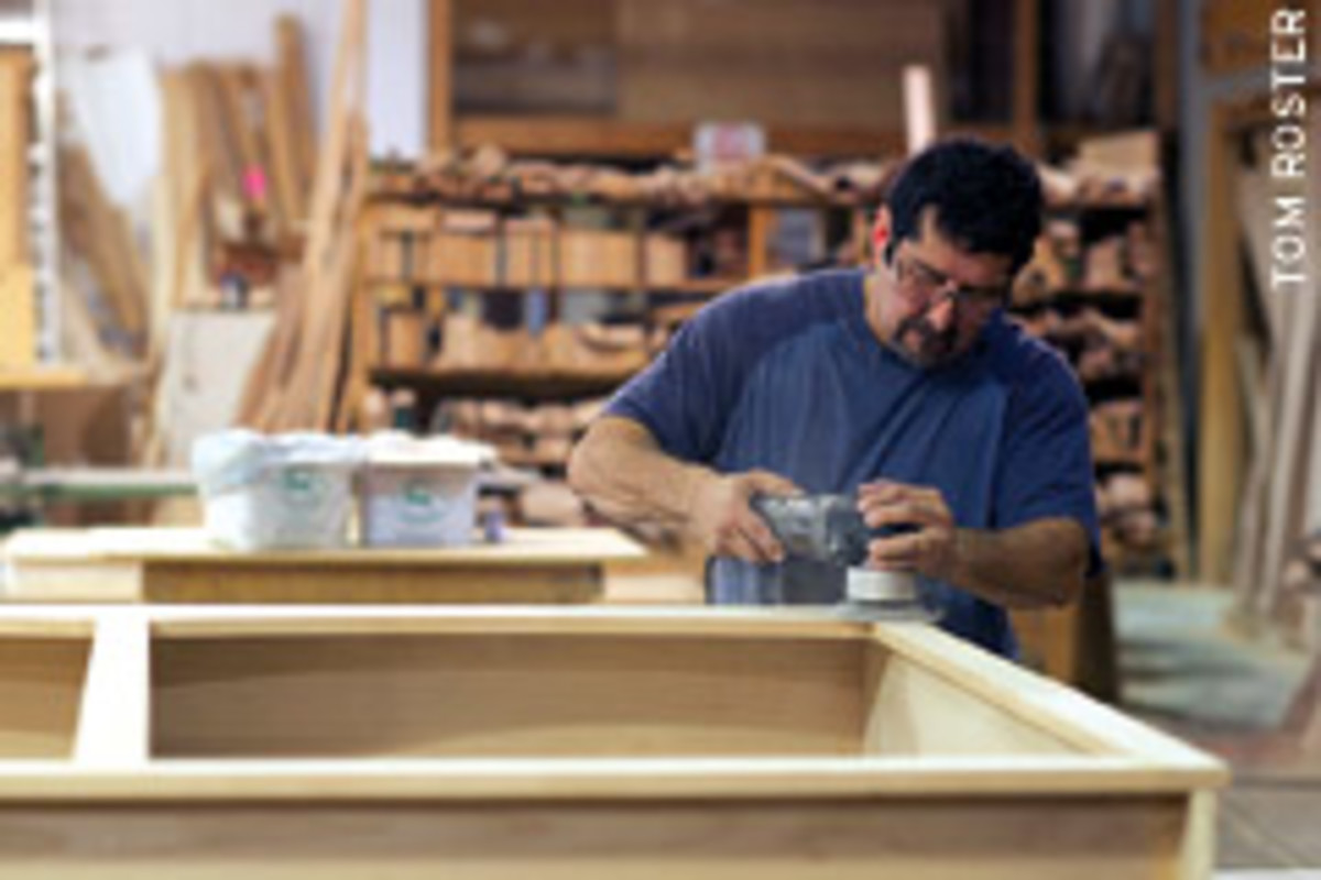 A.J. Osorio sand the face frame of an entertainment center unit in ASH Millwork's shop.
