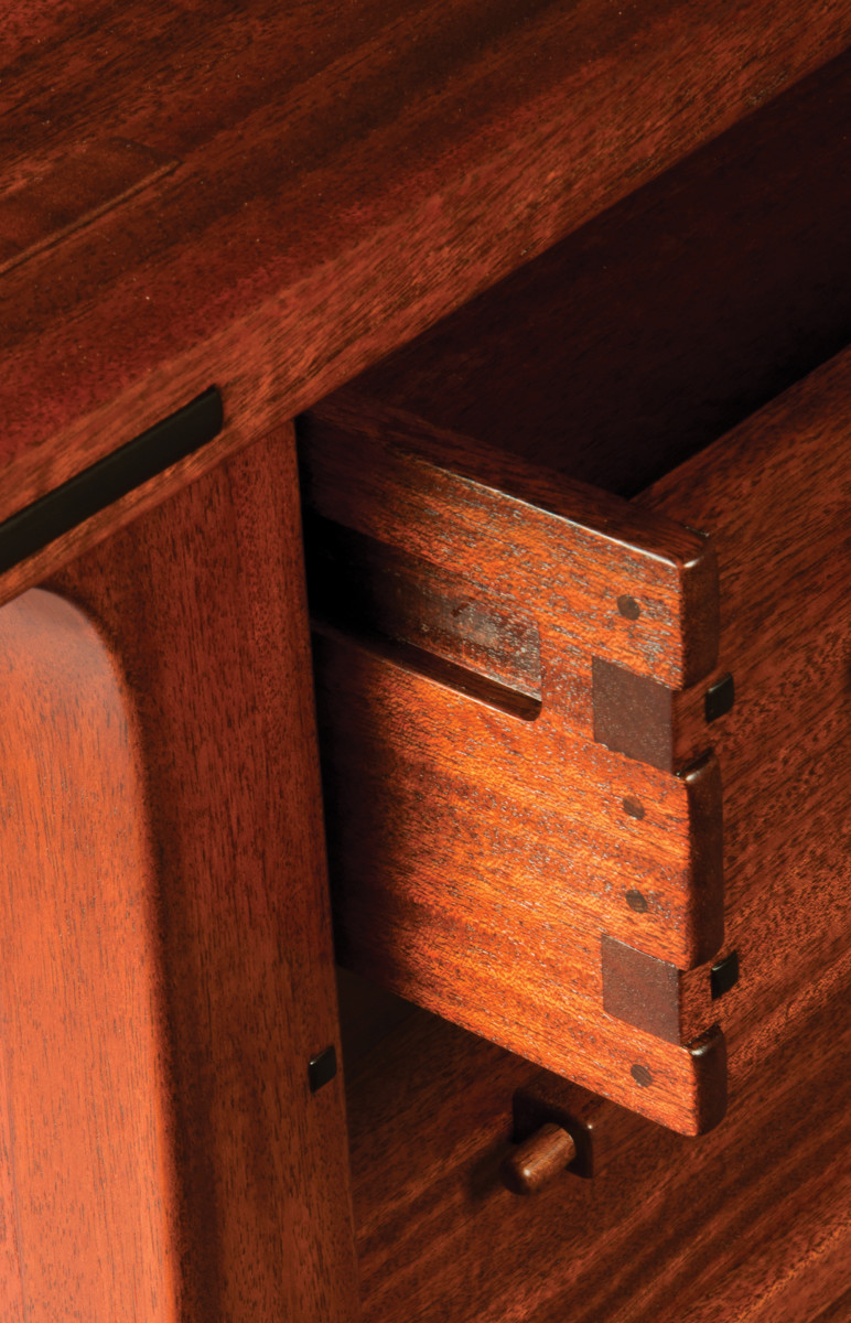 Exposed and highlighted joinery on a drawer shows off the mahogany with ebony accents and showcases the artist's talent.