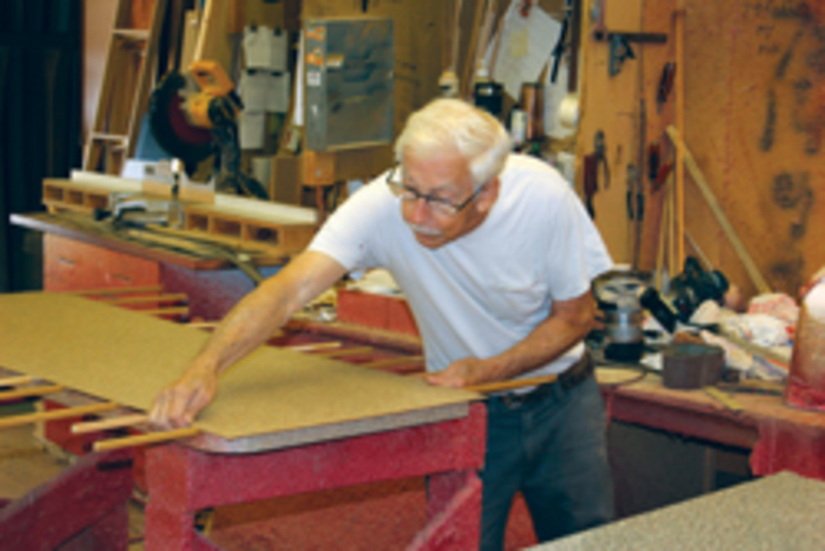 Alonzo Taylor glues a laminate countertop at Custom Woodwork Inc.