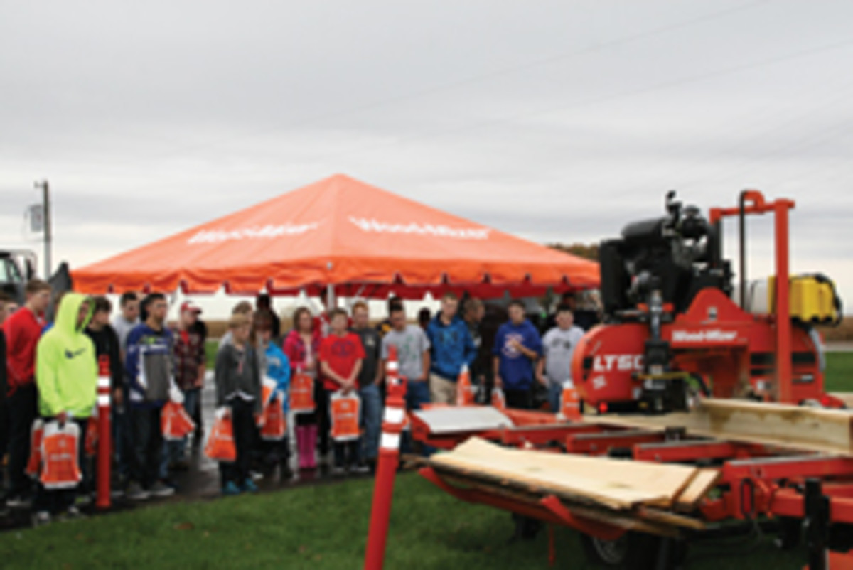 Students from North Decatur High School watch a portable sawmill demonstration at Wood-Mizer's facility in New Point, Ill.