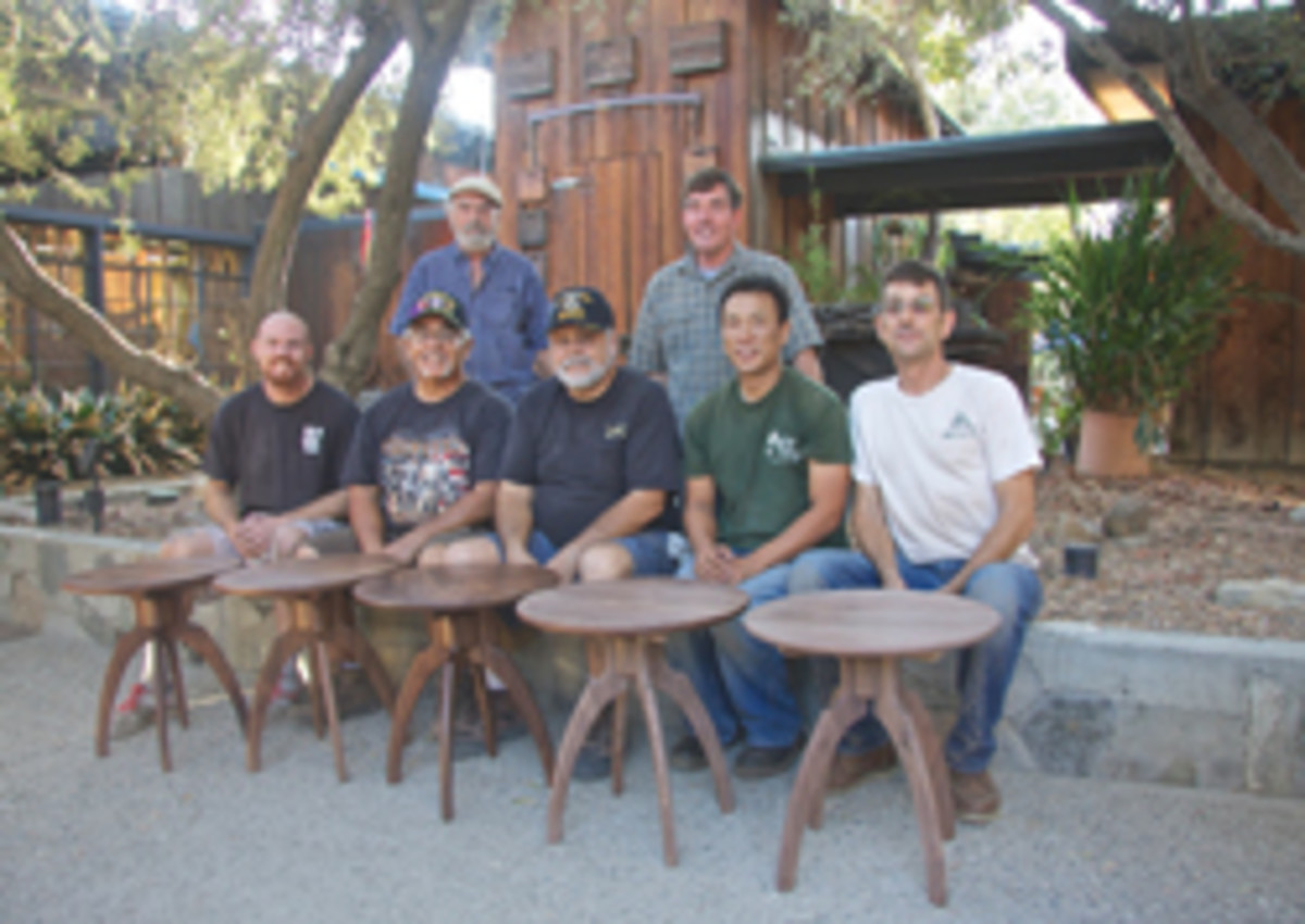 Veterans with their completed tables, made of walnut from Maloof's wood barn.