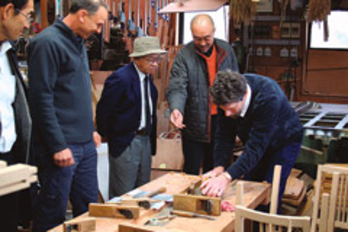 Jeffrey Cooper tries out a Japanese-style plane, which cuts on the pull stroke, at the shop of Toyama-san, a maker of American-style furniture.
