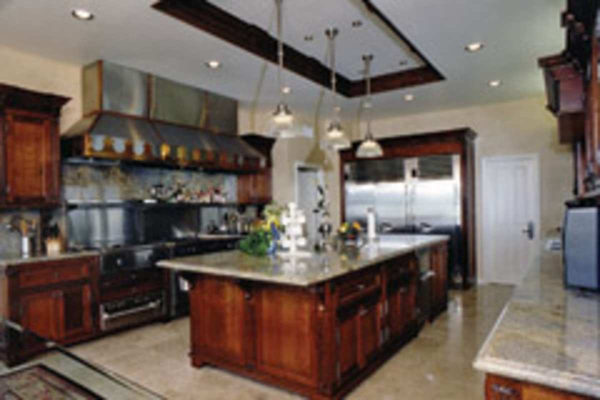 A large range hood, restaurant-style stoves and refrigeration, and task lighting are exhibited in this kitchen by Nelson's Cabinets of Long Beach, Calif.