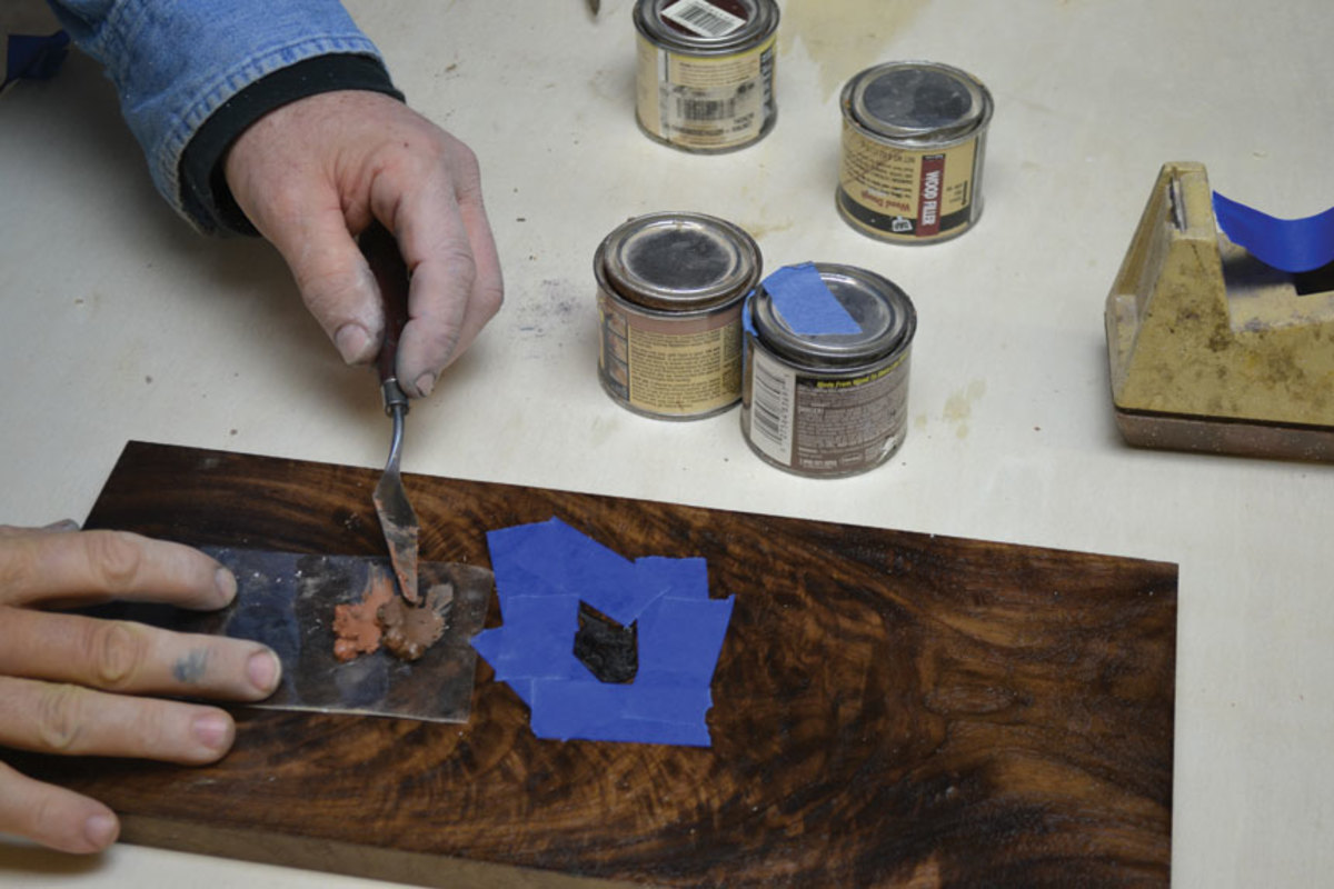 Fill small holes with a solvent-based putty, taping around the defect for a neater job.