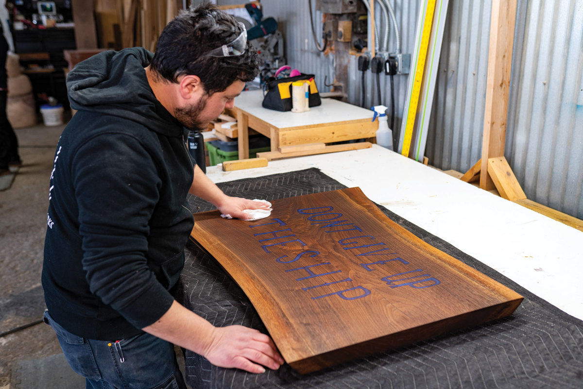Reyes works on a sign commission at his shop in Erie, Pa.