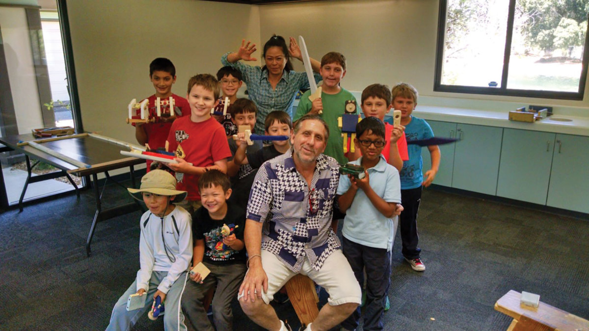 Michael and Jeab Glass, surrounded by students, are the directors of Kids’ Carpentry.