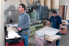 shop-foreman-eric-couture-at-the-controls-of-the-shops-scmi-cnc-router-while-tom-kelly-stacks-machined-panels.jpg